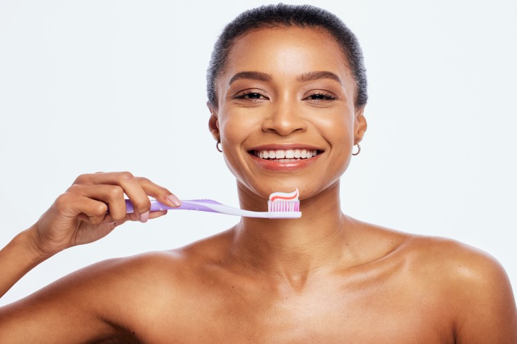 Photo portrait dental and a black woman brushing teeth in studio isolated on a white background for oral hygiene face toothbrush toothpaste with attractive young female posing blank space