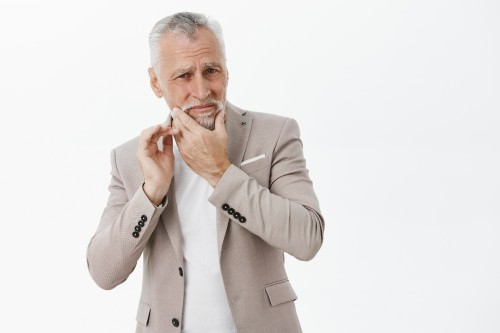 photo bothered senior man in jacket touching jaw, complaining toothache