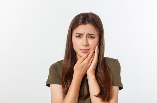 Photo teen woman pressing her bruised cheek with a painful expression as if she is having a terrible tooth