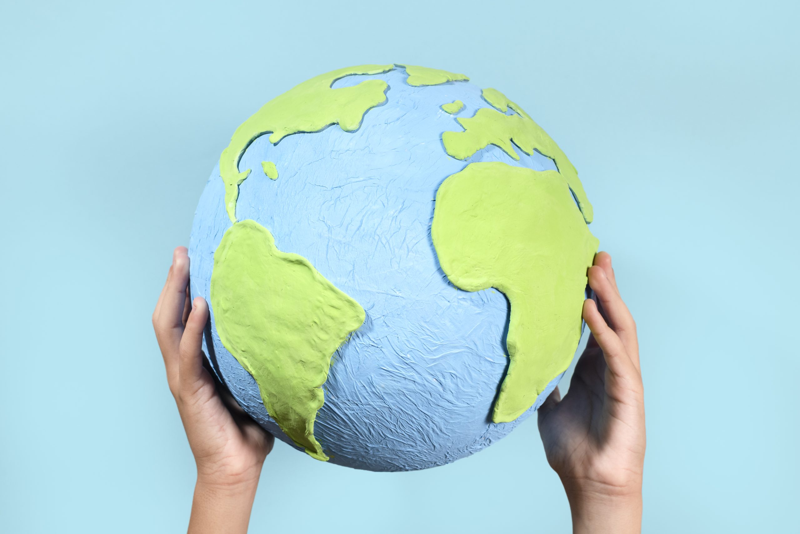 Paper style earth globe shape in hands